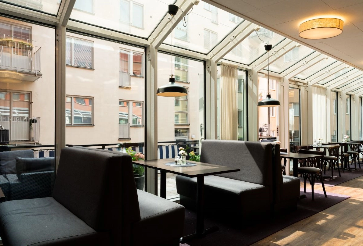 BIlden visar Kom Hotels frukostmatsal. Hela sidan är fönsterbeklädd och ger en skön vy ut mot byggnaderna och terrassen där man om somrarna kan avnjuta sin frukost utomhus.