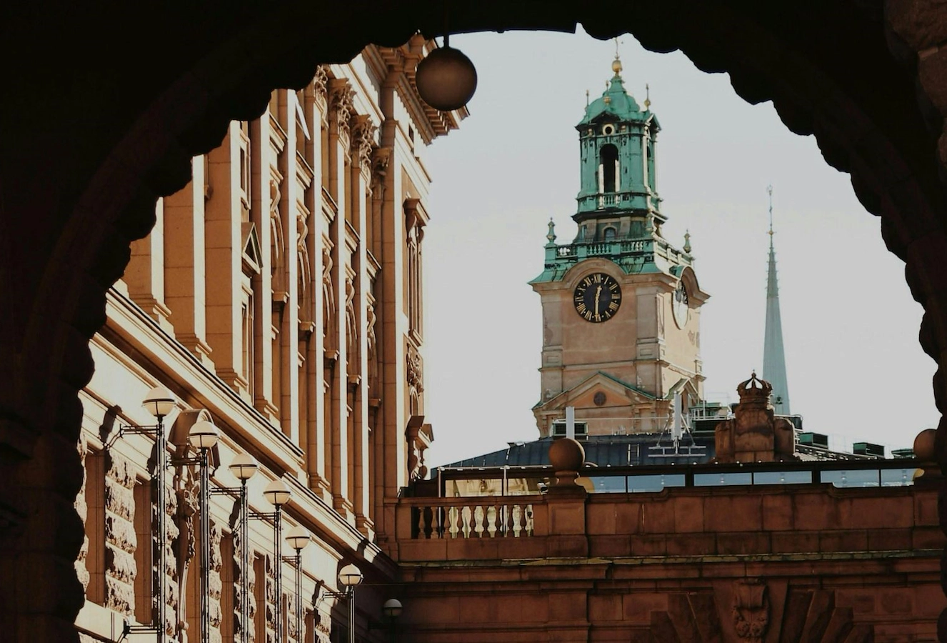 Ett klocktorn i Stockholm sett från och inramat av ett valv