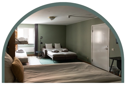 Ett stort hotellrum för en familj. Ett sängskåp, en bäddsoffa och en dubbelsäng i ett rymligt rum.