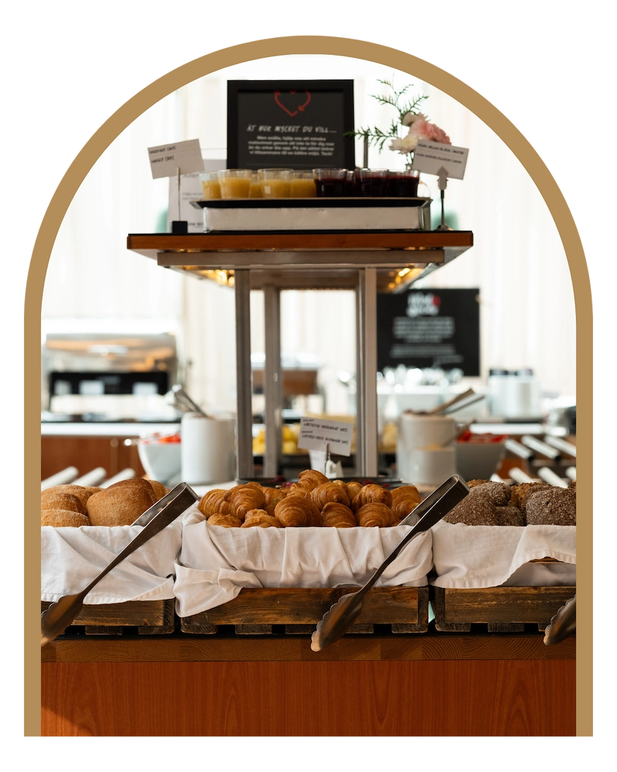 En hotellfrukost med en buffé av bröd. Limpa av mörkt bröd, ljust bröd och frallor. 