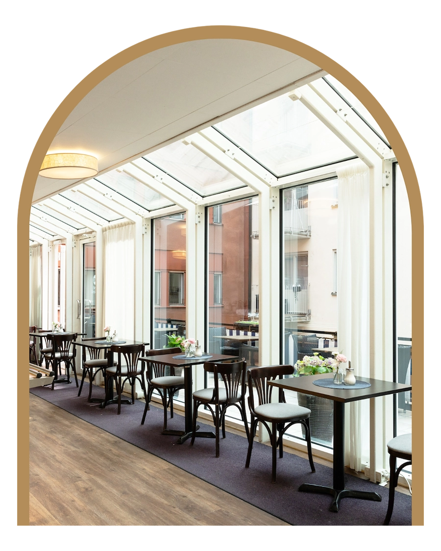 BIlden visar Kom Hotels frukostmatsal. Hela sidan är fönsterbeklädd och ger en skön vy ut mot byggnaderna och terrassen där man om somrarna kan avnjuta sin frukost utomhus.