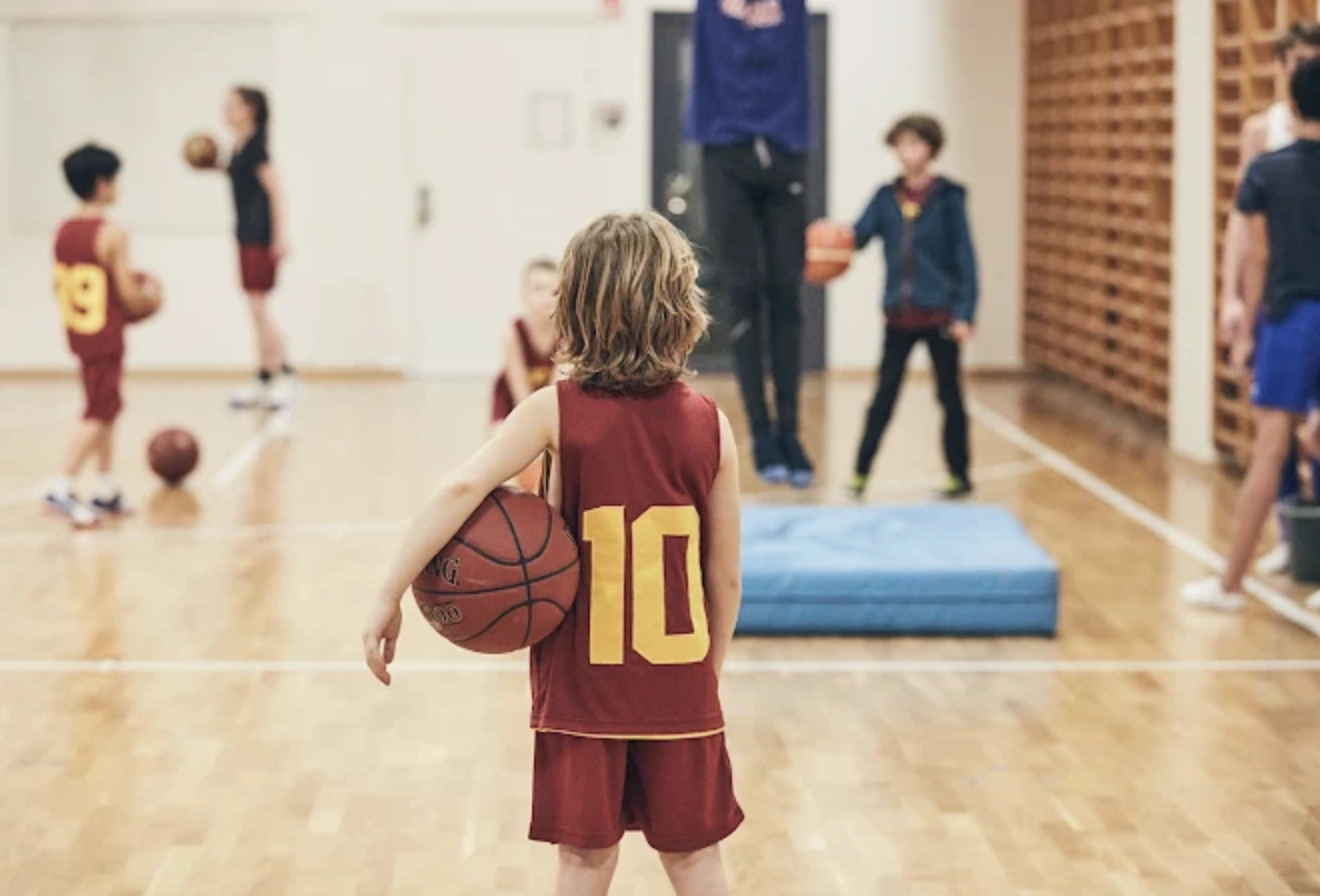Bilden visar basketspelande barn och symboliserar Kfums ägandeskap av Kom Hotel. Överskottet från hotellet går tillbaka till barn- och ungdomsverksamhet.