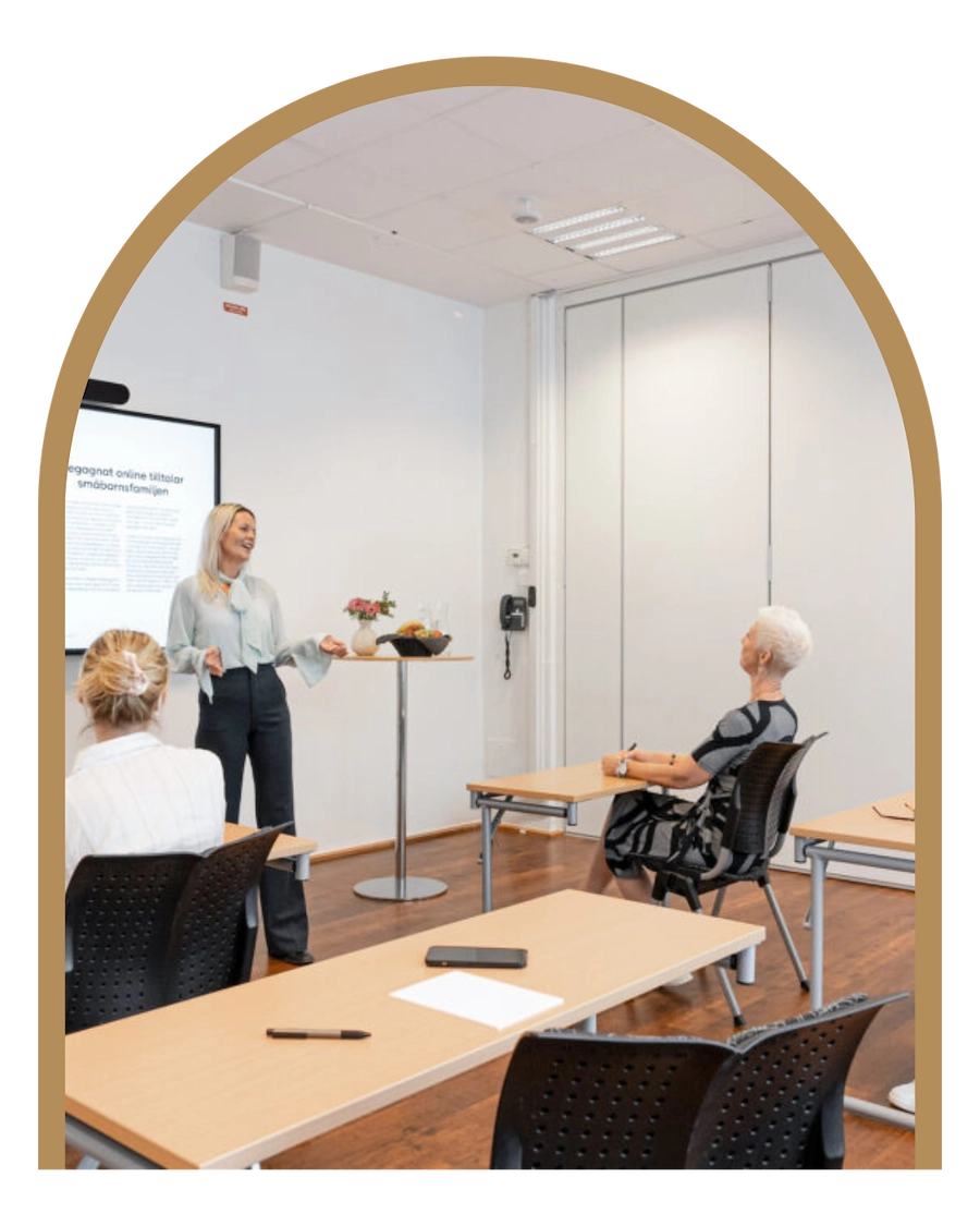 Rummet visar ett konferensrum med tre människor i det 