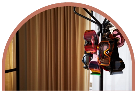 En klädställning som står framför ett fönster på ett hotellrum och i det hänger en massa skid-goggles