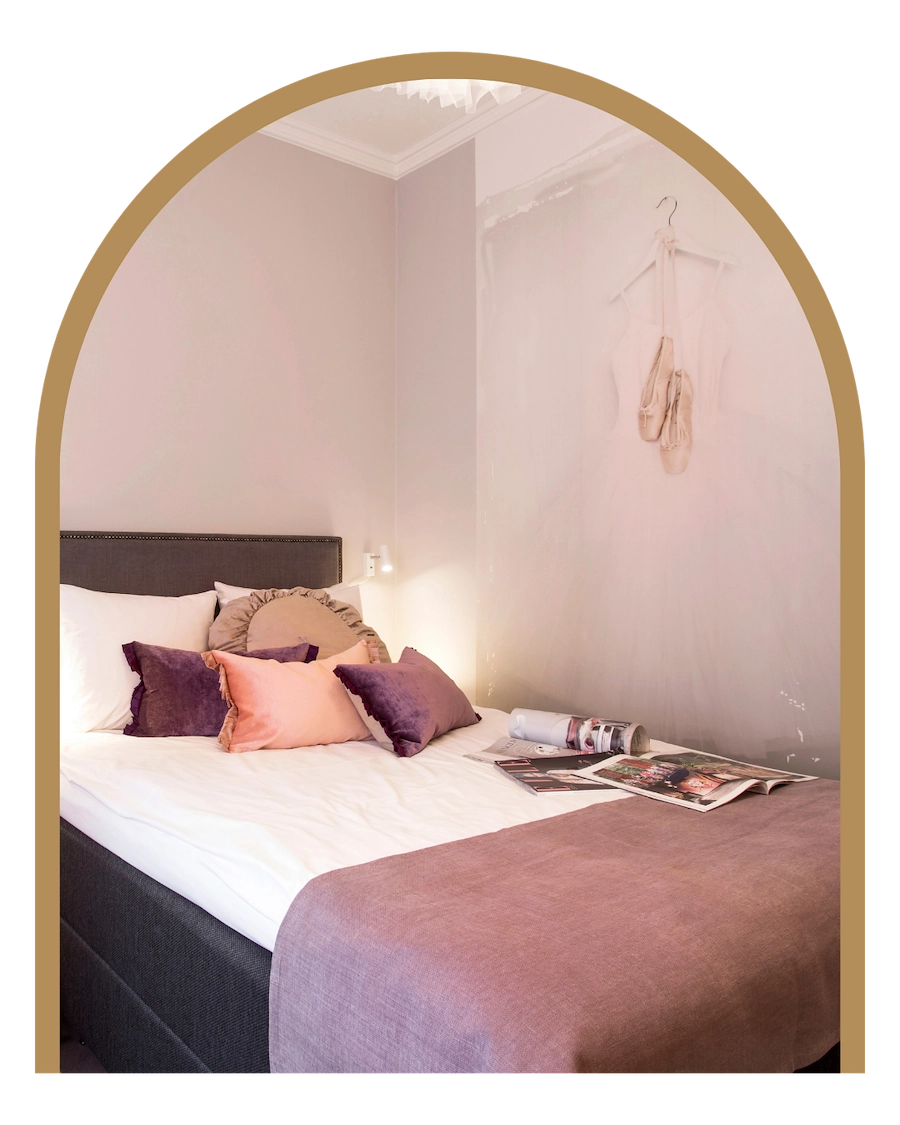 Bilden visar ett av Kom Hotels rum i konceptkorridoren med kvinnlig touch. Rummet går i kvinnligt mjuka färgnyanser och har kvinnliga detaljer så som tapet med balettskor.