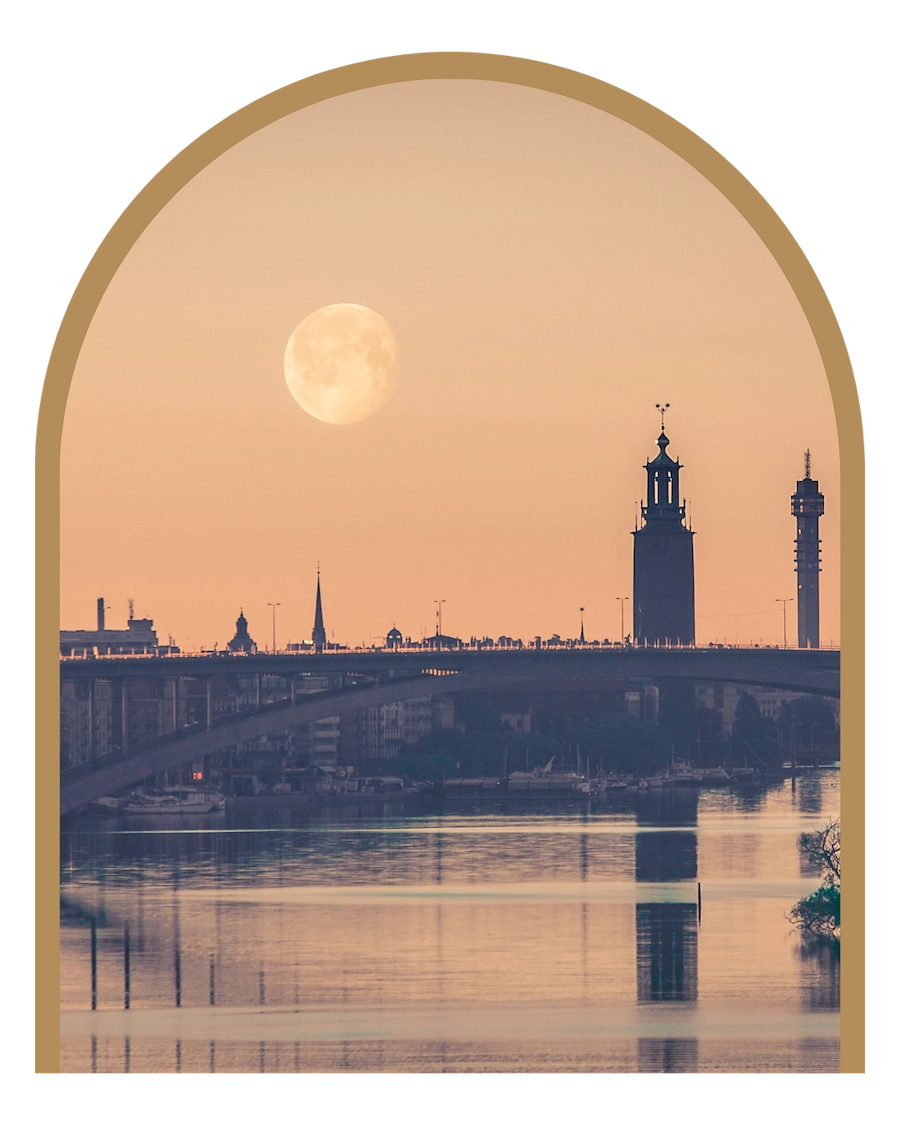 En bild av Stadshuset och en del av Stockholm skyline i skymning med månen och en orange himmel